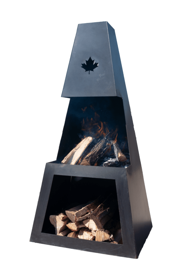 A large metal outdoor fireplace with a maple leaf cutout design, burning wood logs, on a paved area